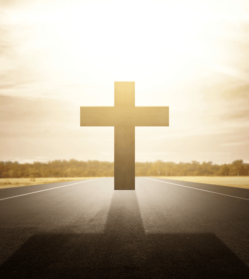 A wooden cross standing on an open road toward a bright horizon